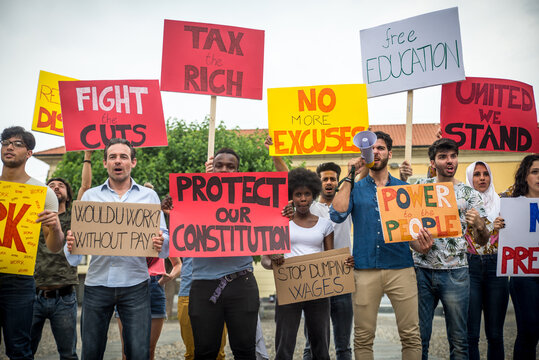 Public demonstration on the street against social problems and human rights. Group of multiethnic people making public protest