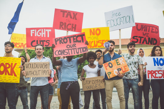 Public demonstration on the street against social problems and human rights. Group of multiethnic people making public protest