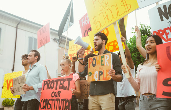 Public demonstration on the street against social problems and human rights. Group of multiethnic people making public protest