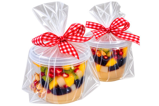 The image shows two transparent containers filled with colorful fruit pudding wrapped in clear plastic and tied with a red and white checkered ribbon, but there is no logo in the image.