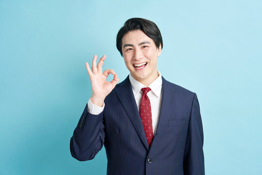 笑顔でOKサインを出すスーツ姿の男性