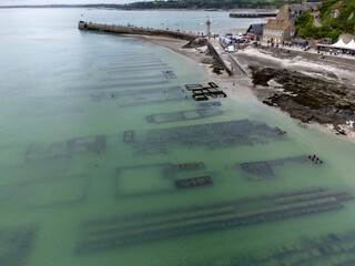 Aerial drone view of underwater oyster farms in Cancale, Brittany, exposed during low tide, raditional sustainable aquaculture and production of premium French oysters, France © barmalini