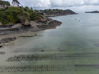 Aerial drone view of underwater oyster farms in Cancale, Brittany, exposed during low tide, raditional sustainable aquaculture and production of premium French oysters, France © barmalini