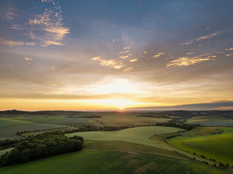 Stunning aerial drone POV landscape English countryside in colorful Summer sunrise