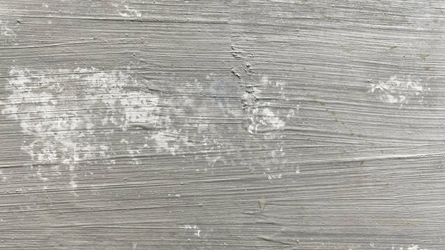 Distressed grey surface texture featuring patchy white peeling paint