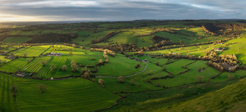 Stunning aerial flying drone landscape images of Thorpe Cloud in Peak Disdtrict during beautiful Autumn sunrise with amazing light