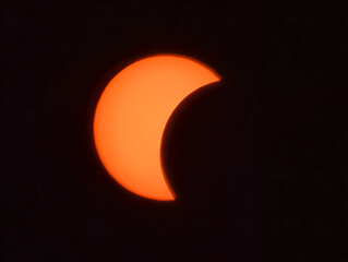 Eclipse solar parcial resplandeciente en un cielo nocturno completamente oscuro, mostrando la silueta en luna del disco solar. © Argiduna