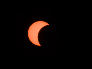 Eclipse solar parcial resplandeciente en un cielo nocturno completamente oscuro, mostrando la silueta en luna del disco solar. © Argiduna