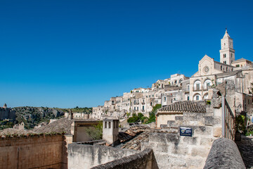 the picturesque city of Matera, Italy, illuminated by bright sunshine, with a prominent view of its stunning cathedral, the Duomo di Matera.  © Wolf Sichalek