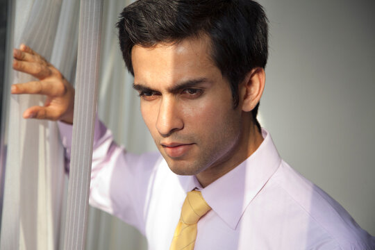 Close-up of handsome young businessman thinking at work 