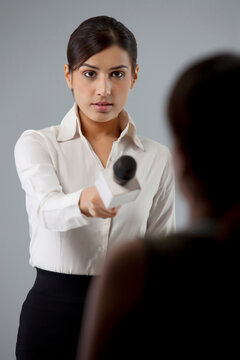 Young female reporter taking interview of a person 