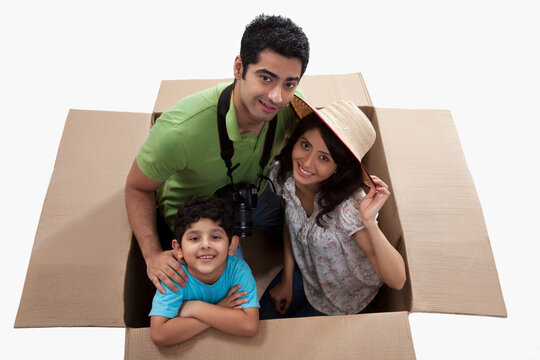 Happy family on vacation smiling inside cardboard box 