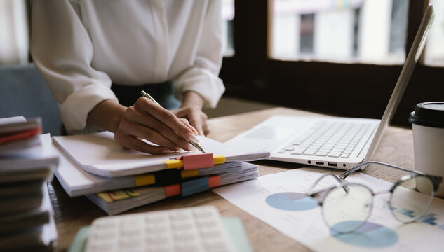 A woman in a red shirt is handling a large number of documents and files, symbolizing office work, documentation, organization, management, deadlines, workloads, bureaucracy, and business responsibili
