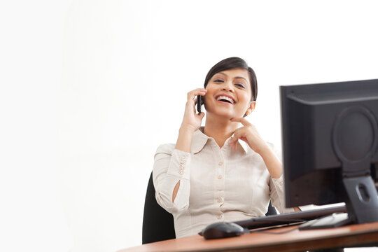 Cheerful businesswoman enjoying conversing on call 