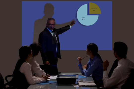 Businessman giving presentation on projection screen in seminar 
