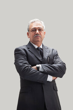 Successful mature businessman standing with arms crossed 