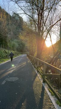 Elderly man hiking on a scenic trail at sunset