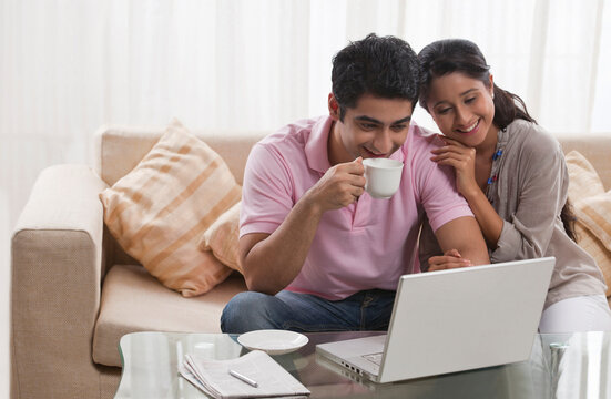 Young smiling couple looking at laptop together 