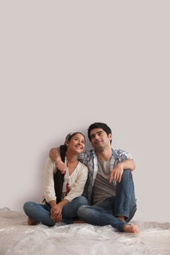 Full length of relaxed young couple looking up at copy space 