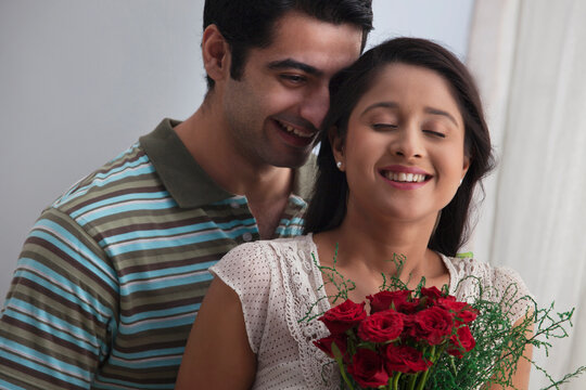 Young couple together with bouquet at home 