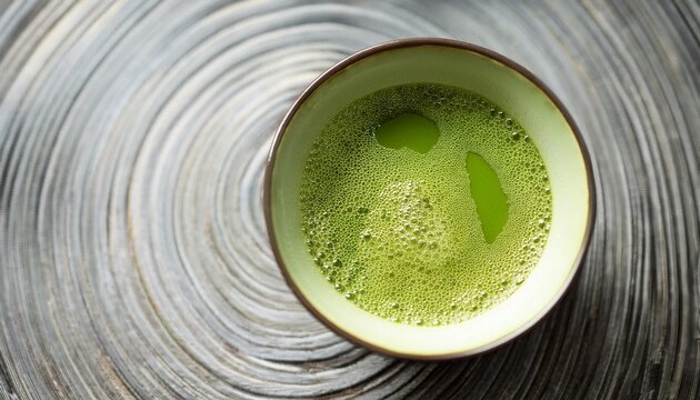 bowl of fresh green matcha tea with frothy bubbles ideal for wellness and healthy living