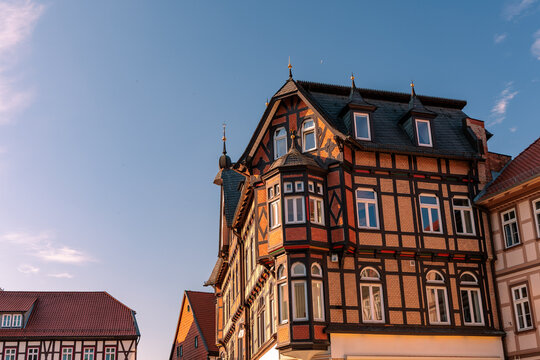 Historic timber framed house with bay window illuminated by golden hour sunlight in Wernigerode old town, German traditional architecture concept