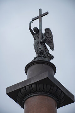 Angel statue with cross on top of Alexander Column with grey sky copy space