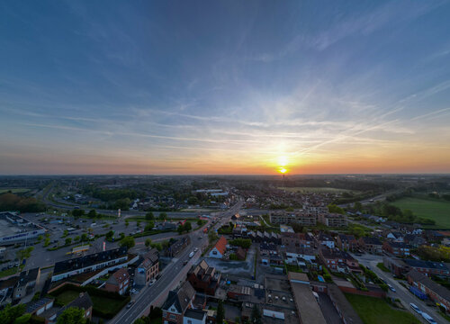 Lier, Antwerp, Belgium, 28th of April, 2025, A stunning sunset casts warm hues over the city, illuminating roads and buildings with a gentle glow