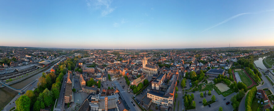 Halle, Vlaams Brabant, Belgium, 27th of April, 2025, Captivating aerial panorama showcasing a vast cityscape beautifully illuminated by the enchanting golden hour light