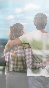 Animation of windows over couple embracing looking at cityscape