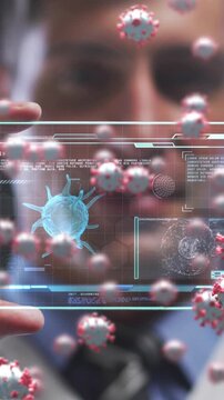 Animation of covid 19 cells over man holding screen with covid 19 cell and medical data processing