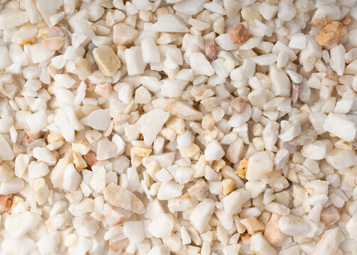 Crushed quartzite pebble textured background, white decorative marble stones close up