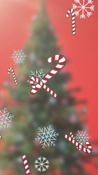 Animation of falling snowflakes and candy corns over christmas tree
