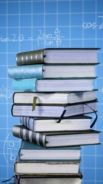 Pile of books and mathematical equations and graphs