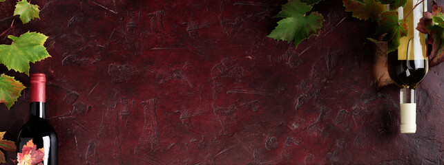 Naklejka premium Red Wine Bottles and Glass with Grapevine on Rustic Background