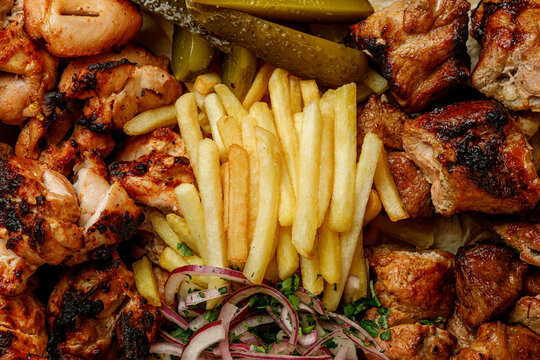 Grilled meat platter with pork and chicken shish kebab and french fries