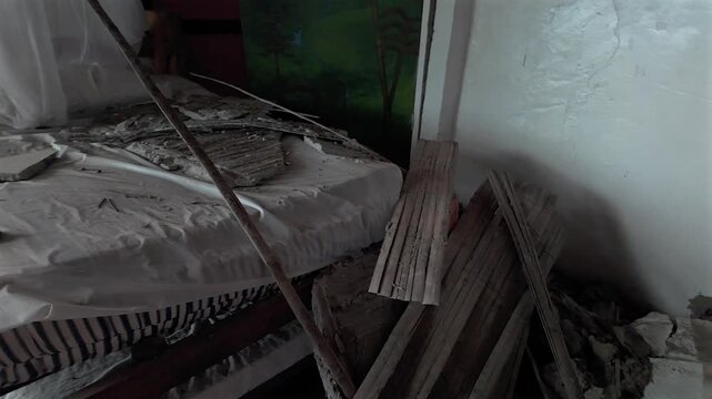colombia earthquake bedroom interior with collapsed ceiling and wall debris