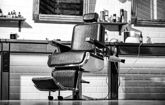 Barber shop chair. Hair salon, barber shop for men. Stylish vintage barber chair. Professional hairstylist in barbershop interior. Black and white