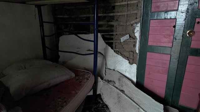 earthquake damage inside a bedroom with collapsed wall and bunk beds in colombia