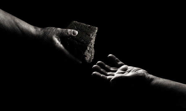 Hunger concept. Hands grabbing for bread. Old man giving poor homeless person pieces of bread. Helping the homeless. Black and white