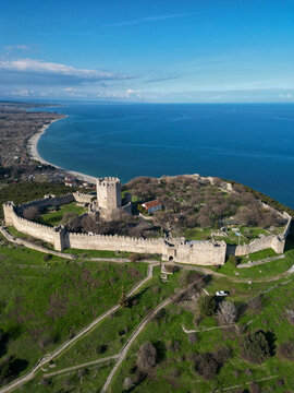 Aerial view of Platamon Castle, a medieval fortress with stone walls and a central tower, situated on a hill overlooking the Aegean Sea in Platamon, Greece.