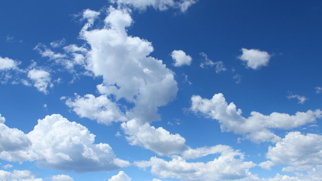 Puffy White Clouds in Blue Summer Sky Background