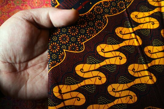 The main section of the fabric features the Parang motif, characterized by golden-yellow, wavy diagonal lines resembling the letter S.