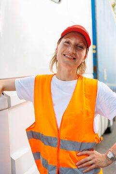Portrait young adult happy smiling woman heavy truck driver modern cargo vehicle cabin background. Female person girl professional job career working driving freight engine lorry. Logistics industry