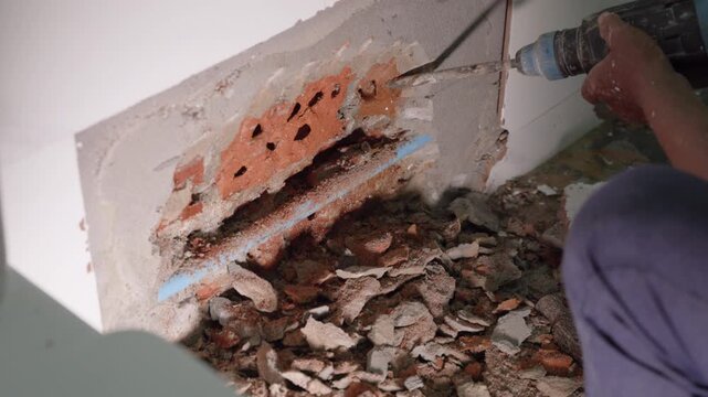 Exposed plumbing pipe inside a cracked wall reveals hidden home maintenance problems, water leakage, moisture damage, corrosion, renovation work, and the need for professional repair.
