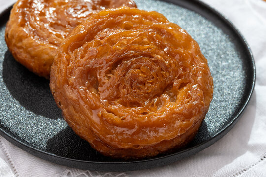 Kouign-amann legendary Breton confection from Douarnenez,  Saint-Malo, Brittany with butter, sugar, puff dough, crispy caramelized layers, authentic French pastry with centuries-old tradition