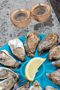 Fresh oysters on plastic plates aready to eat, Brittany fish market stall in coastal village Cancale, famous oysters farms by Atlantic ocean, France