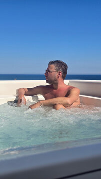 Relaxing in a hot tub overlooking the stunning coastline of Milos, Greece