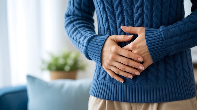 Digestive discomfort concept with person holding abdomen at home