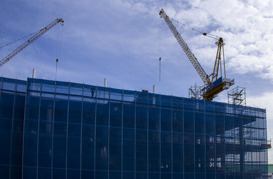 Construction building crane scaffolding blue sky industrial architecture structure development. Construction site with cranes and scaffolding blue sky industrial building development modern